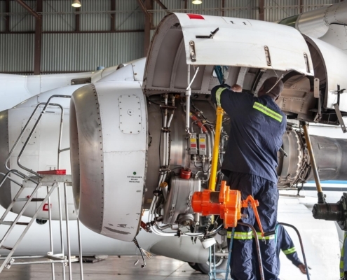 Worker Inspecting Jet Engine