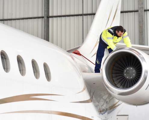 Person Working On Aeroplane In Hangar