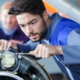 Worker Checking Airplane Engine In Airport Hangar